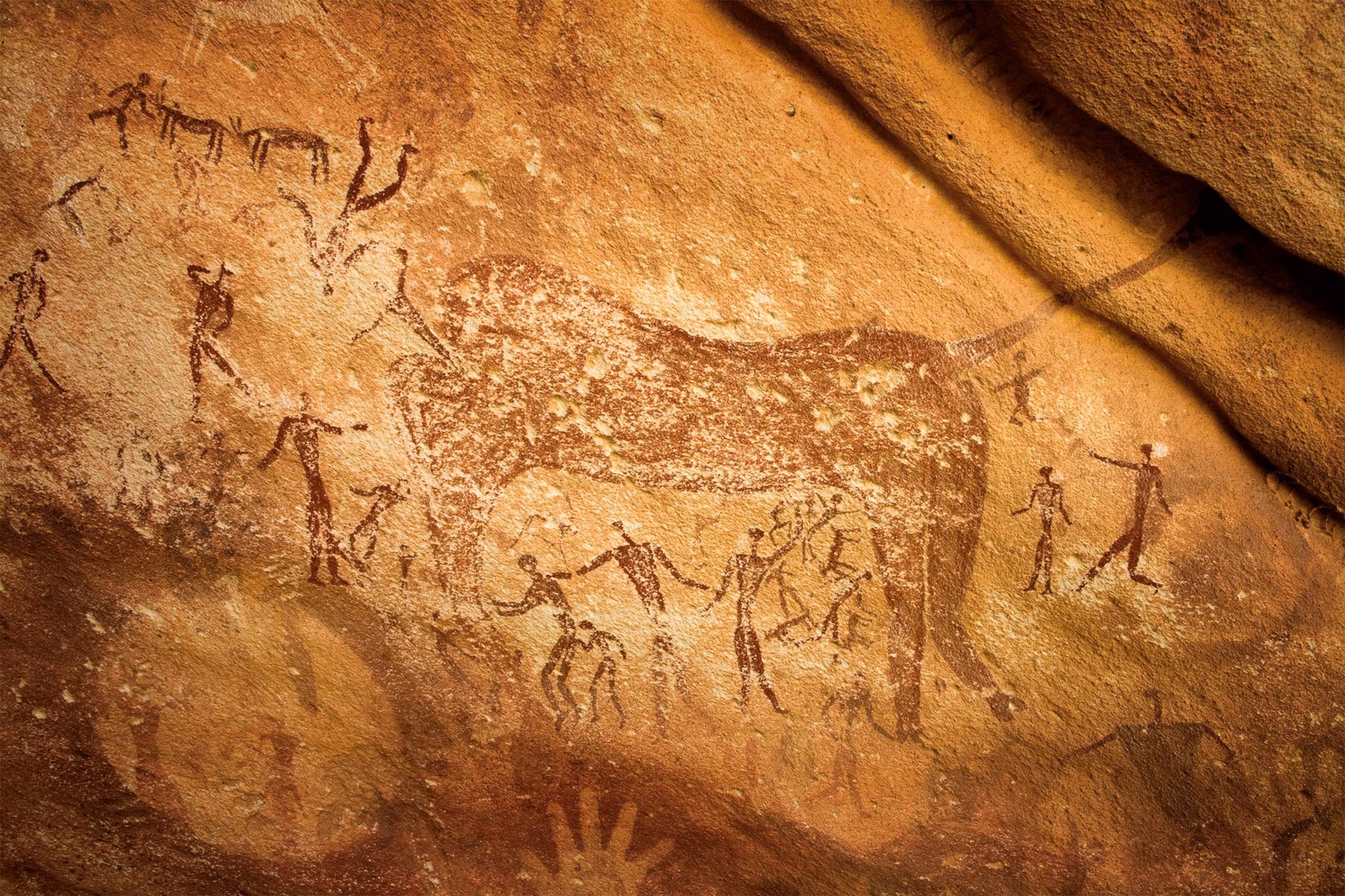 Ancient cave paintings depicting hunters and large animal in Gilf Kebir National Park sandstone rock art