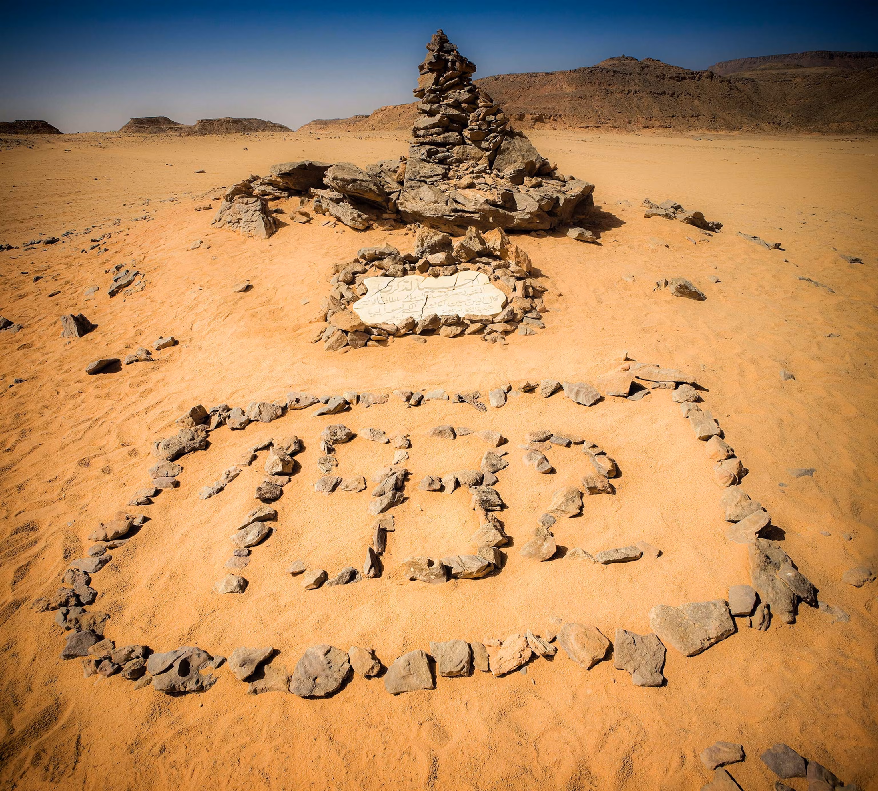 WWII stone circle and cairn in desert landscape of Gilf Kebir National Park, Egypt