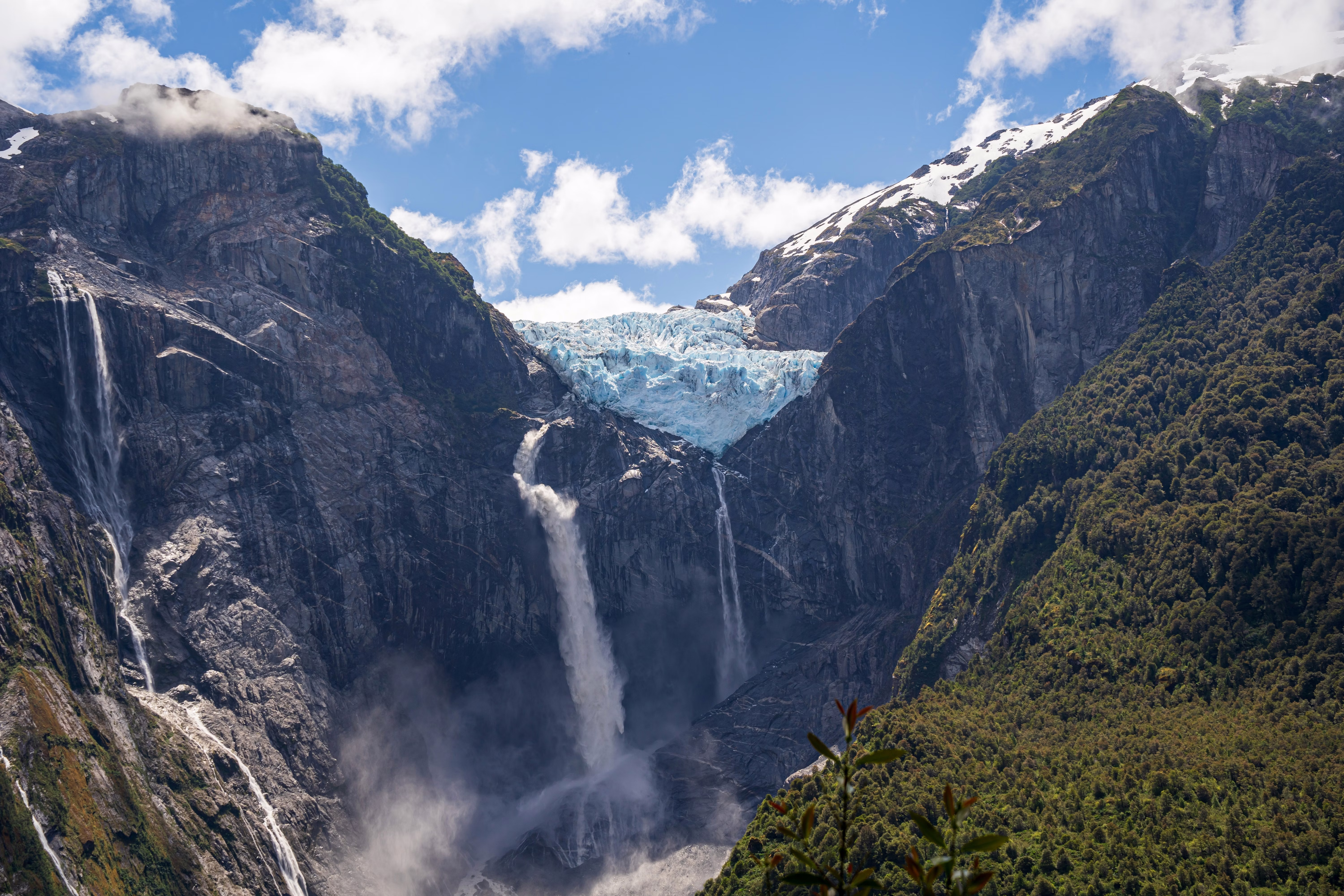 Dramatic glacier and waterfalls cascading down steep mountain valley in Chilean Patagonia