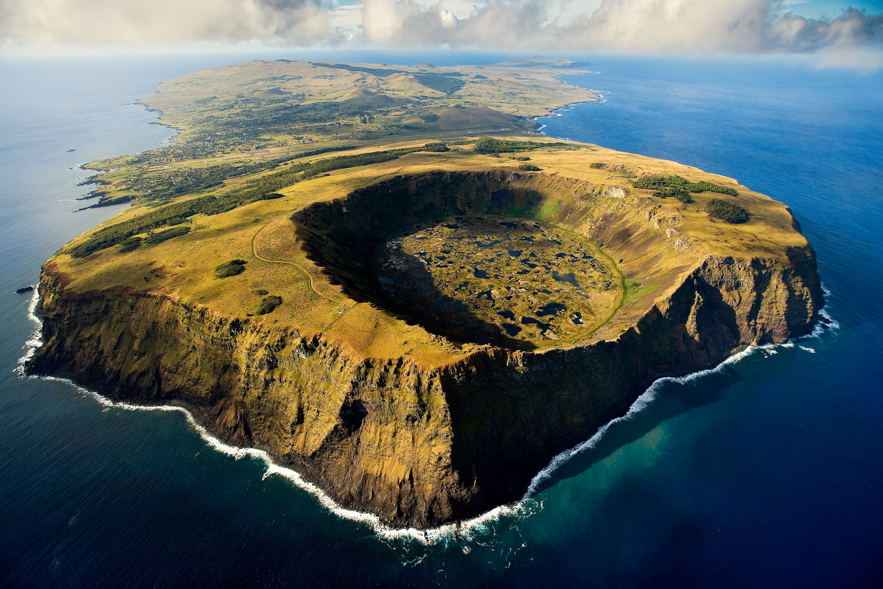 Aerial view of Rano Raraku volcanic crater lake on Easter Island with dramatic cliffs and pristine Pacific waters